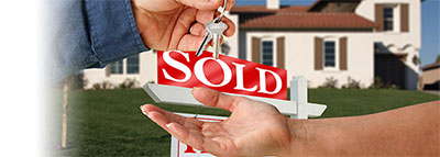 one person handing keys to home with sold sign