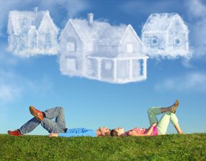 couple lying on grass looking at clouds shaped as houses