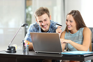 smiling couple looking at laptop screen
